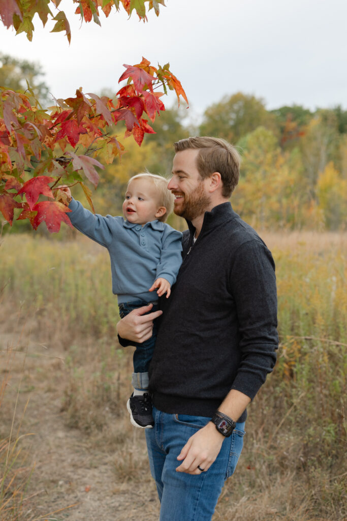 Little boy playing with leaves during Fall Mini Sessions at West Park with Capturing Simplicity Photography