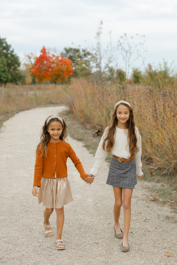 Sisters walking during Fall Mini Sessions at West Park with Capturing Simplicity Photography