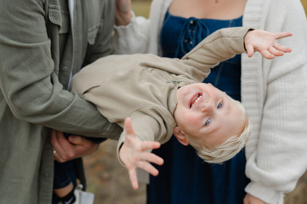 little boy smiling upside down during Fall Mini Sessions at West Park with Capturing Simplicity Photography