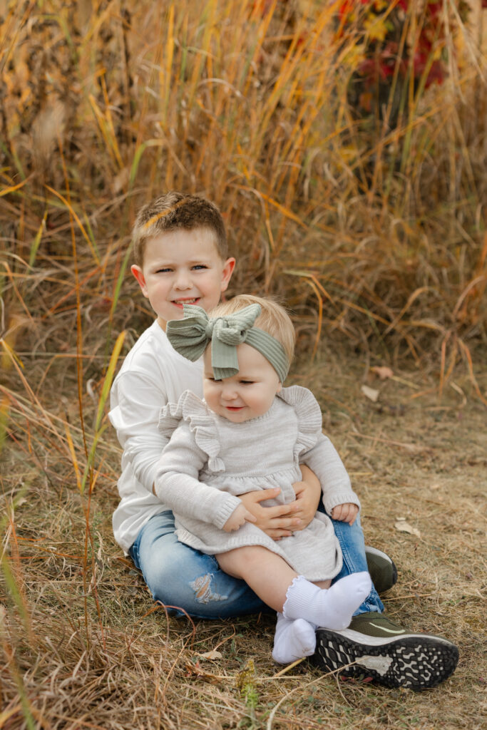 brother holding sister during Fall Mini Sessions at West Park with Capturing Simplicity Photography