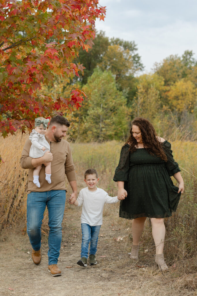 Family walking on fall path during Fall Mini Sessions at West Park with Capturing Simplicity Photography