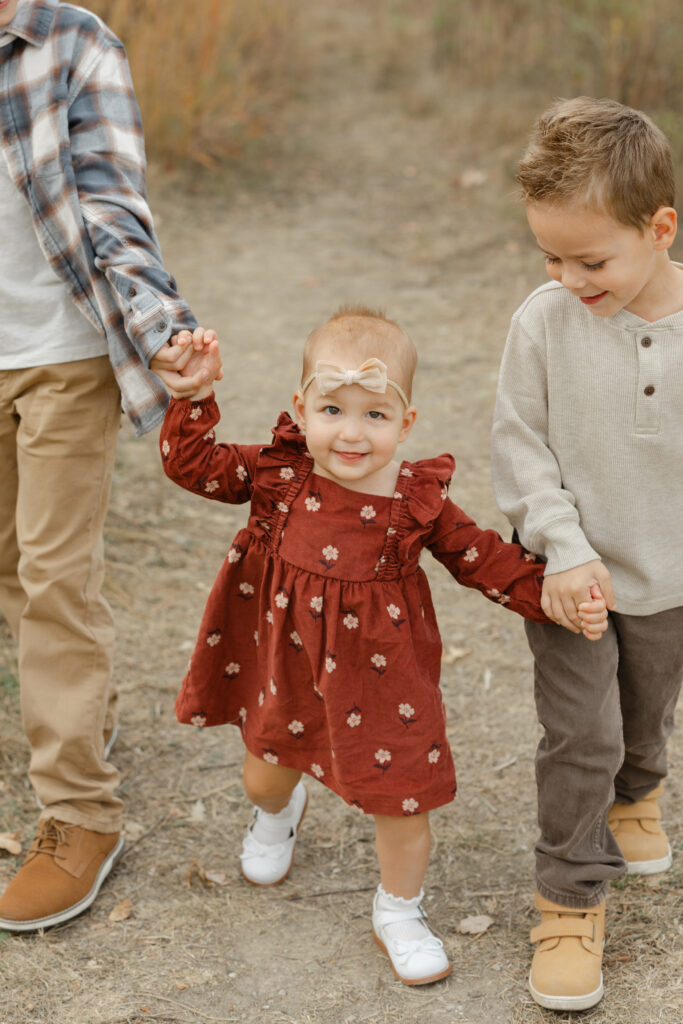 brothers walking little sister during Fall Mini Sessions at West Park with Capturing Simplicity Photography