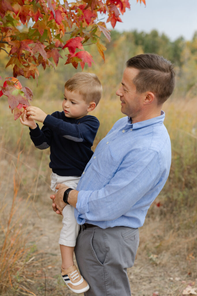 Little boy playing with leaves during Fall Mini Sessions at West Park with Capturing Simplicity Photography