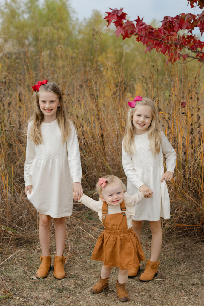 Little sister walking with help during Fall Mini Sessions at West Park with Capturing Simplicity Photography