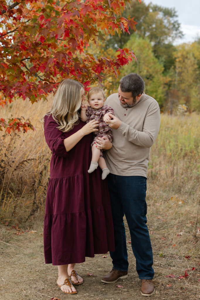 Family tickling baby boy during Fall Mini Sessions at West Park with Capturing Simplicity Photography