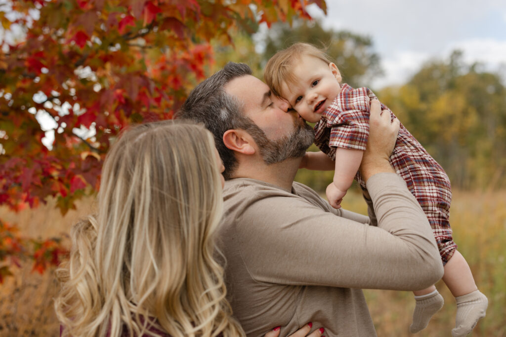 Family playing with baby boy during Fall Mini Sessions at West Park with Capturing Simplicity Photography