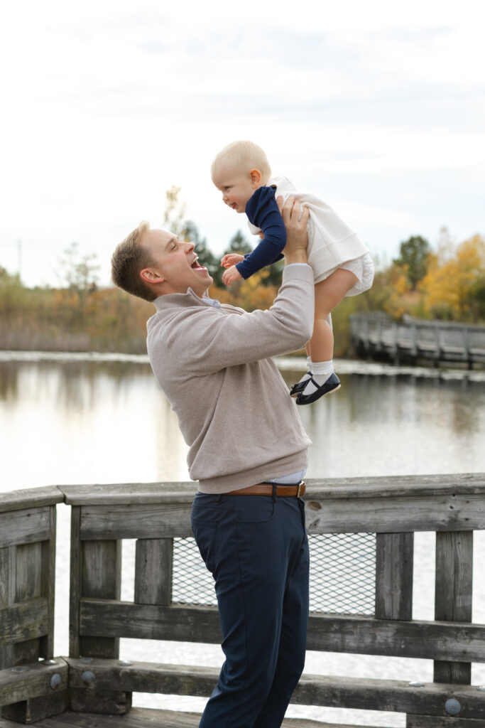 Dad playing with daughter by water during Fall Mini Sessions at West Park with Capturing Simplicity Photography