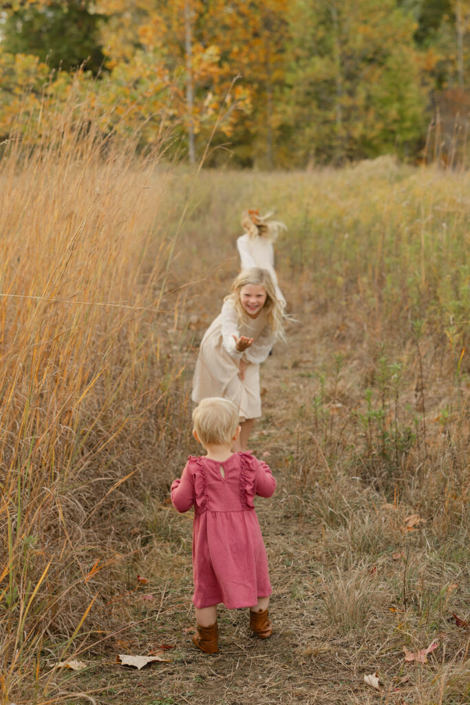 sisters walking during Fall Mini Sessions at West Park with Capturing Simplicity Photography