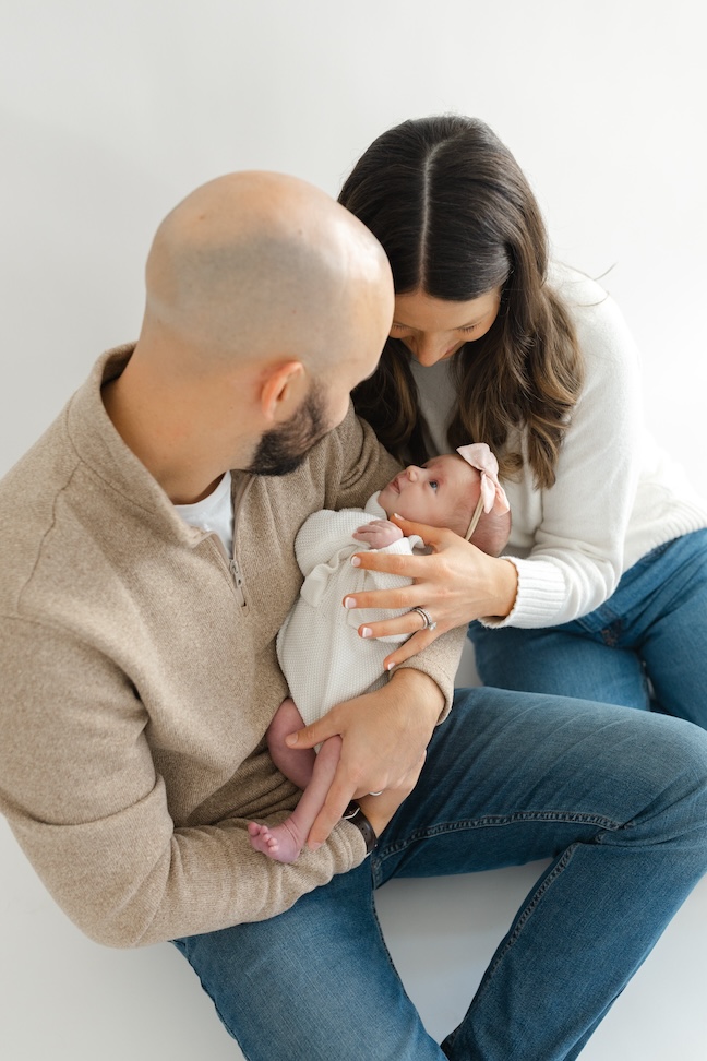 Newborn girl looking up towards her parents during newborn photos with Indianapolis Newborn Photographer Capturing Simplicity Photography