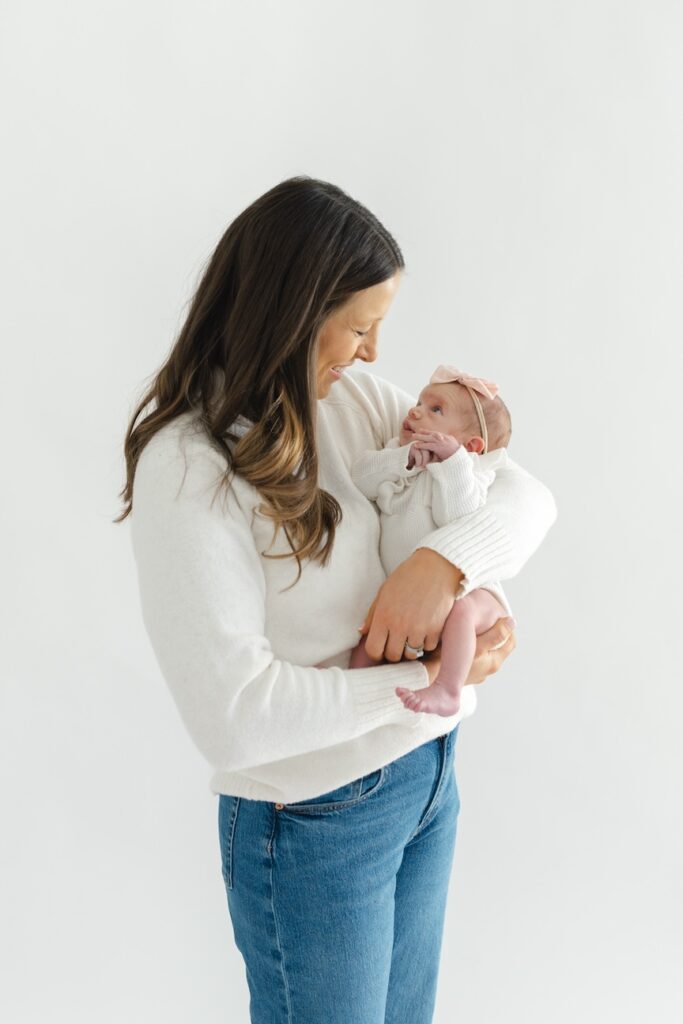 Mom looking lovingly towards her baby girl during newborn photos with Indianapolis Newborn Photographer Capturing Simplicity Photography