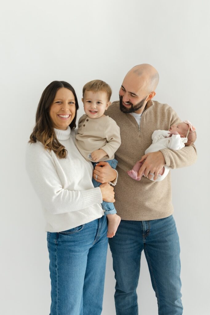 Family lovingly smiling during newborn photos with Indianapolis Newborn Photographer Capturing Simplicity Photography
