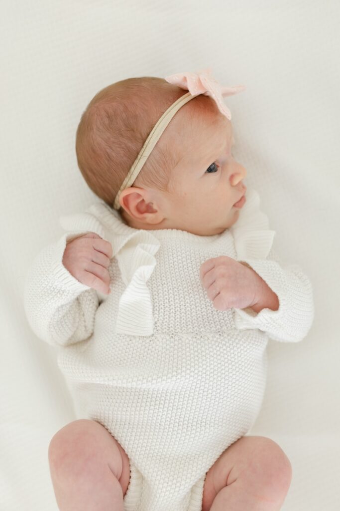 Little girl with pink bow during newborn photos with Indianapolis Newborn Photographer Capturing Simplicity Photography
