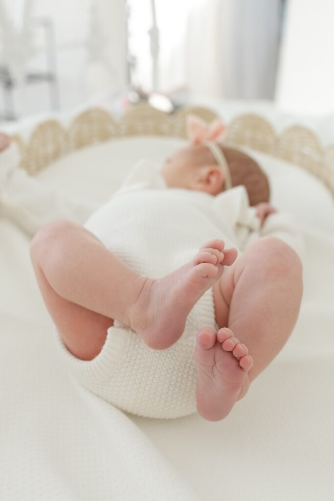 Detail photo of newborn feet with baby in background during newborn photos with Indianapolis Newborn Photographer Capturing Simplicity Photography