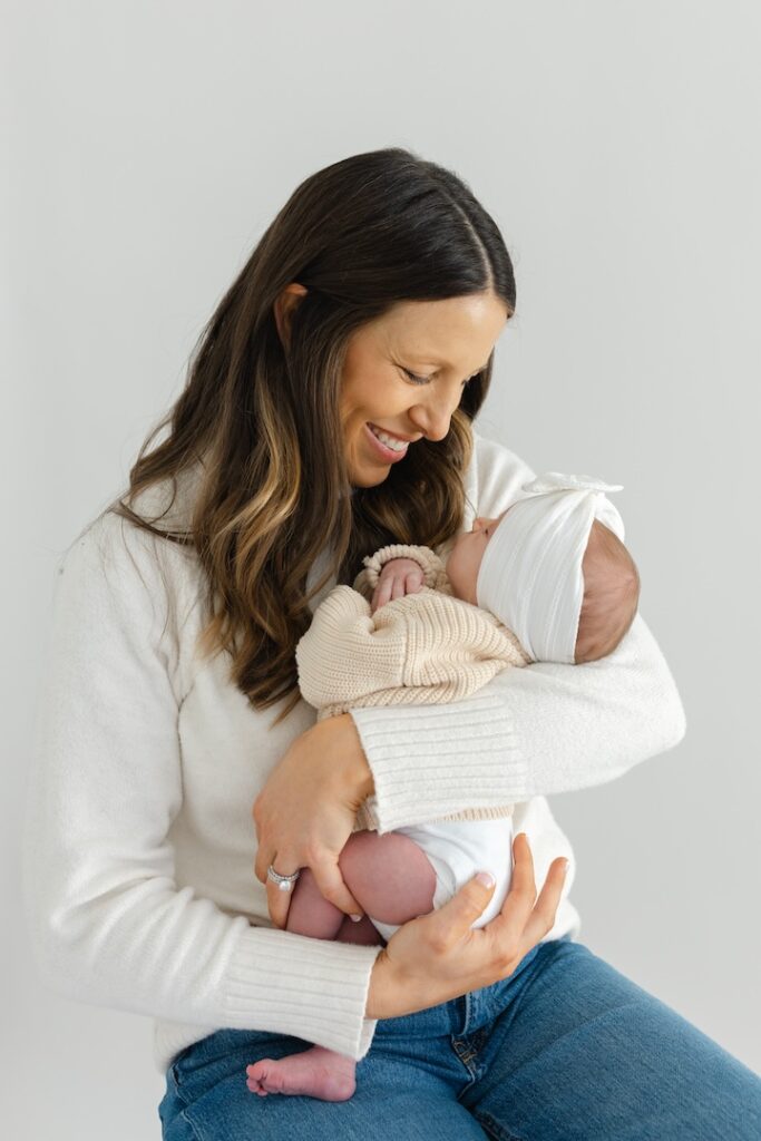 Mom smiling down towards her baby girl during newborn photos with Indianapolis Newborn Photographer Capturing Simplicity Photography
