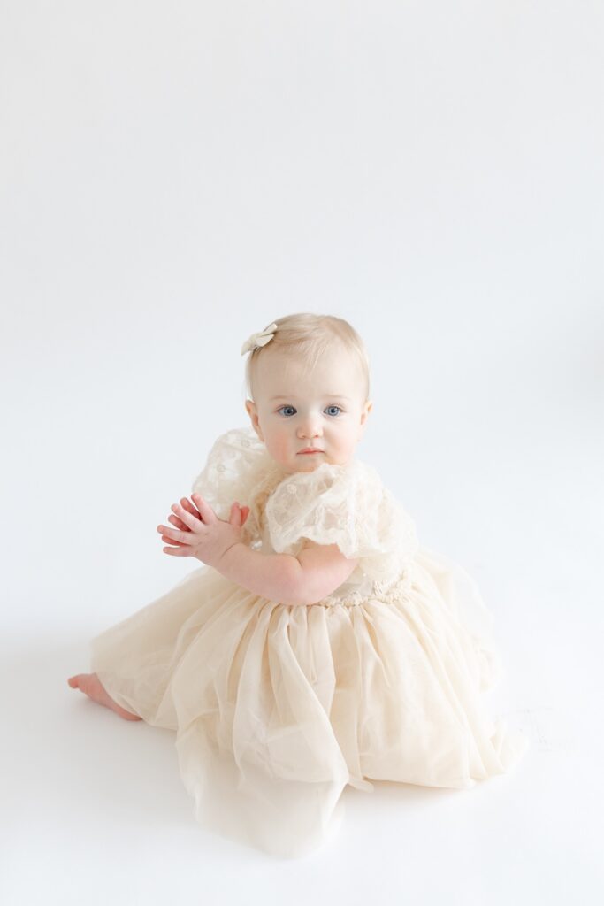 Baby girl sitting in studio during first birthday photos in Indianapolis with Capturing Simplicity Photography